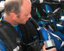 Dive team member Matt Ferraro checks his dive computer to make sure the in-line oxygen sensor is monitoring the mix in his bag. © Tom Ordway, Ocean Futures Society Dive Prep