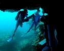Filming the cave formations on the Western most tip of Maro Reef, cinematographer Yves Lefevre captures Jean-Michel Cousteau and expedition dive team member Holly Lohuis examining the diversity of "macro" life clinging to the underside of the ledge. ©: Tom Ordway, Ocean Futures Society Maro Reef